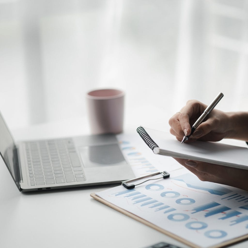 A businesswoman is taking notes in a notebook.